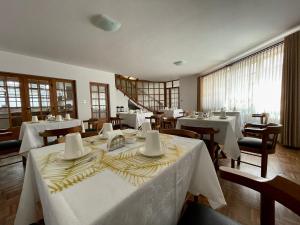 jadalnia z białymi stołami i krzesłami w obiekcie HOSPEDAJE SARABIA w mieście Sucre