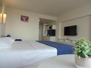 um quarto de hotel com uma cama e uma televisão em Orbi City Superhost em Batumi