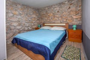 a bedroom with a bed and a stone wall at House Neda in Ražanj +31 photos