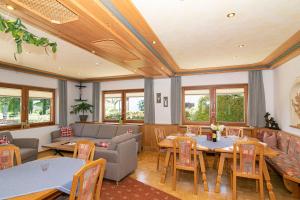 a restaurant with tables and chairs and a couch at Ferienhaus Ostara GbR in Ruhpolding