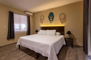 um quarto com uma grande cama branca e uma janela em Ammare Hotel Boutique em Playa del Carmen