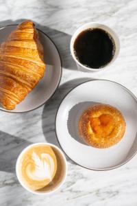 uma mesa com três pratos de comida e chávenas de café em Hotel Per La, Autograph Collection em Los Angeles