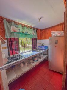 a kitchen with a white refrigerator and a window at CABAÑAS Finca Hotel Villa Natalia -Salento Quindio in Salento