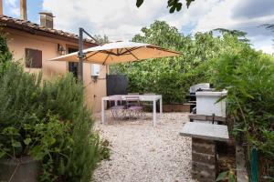 a patio with a table and an umbrella at Casaletto Del Pellegrino in Viterbo