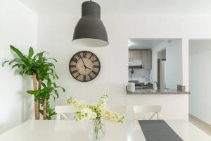 eine weiße Küche mit einer Uhr an der Wand in der Unterkunft Relax Apartment to enjoy! in Santiago de los Caballeros