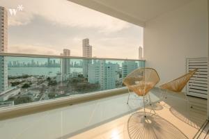 カルタヘナ・デ・インディアスにあるWynwood Las Flores in Cartagenaの大きな窓(椅子付)が備わる白い客室です。