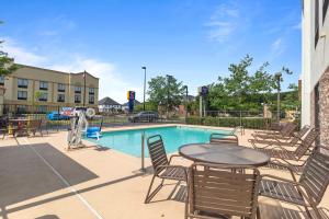 a patio with a table and chairs next to a pool at Hampton Inn Atlanta-Woodstock in Woodstock