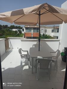 einen Tisch und Stühle mit Sonnenschirm auf dem Balkon in der Unterkunft House San cataldo in San Cataldo