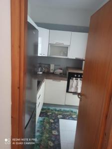 eine Küche mit weißen Schränken und einer offenen Tür in der Unterkunft House San cataldo in San Cataldo