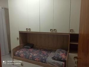 ein kleines Bett in einem Zimmer mit weißen Schränken in der Unterkunft House San cataldo in San Cataldo