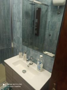 ein Waschbecken mit einer Dusche und einem Spiegel in der Unterkunft House San cataldo in San Cataldo