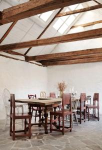 - une salle à manger avec une table et des chaises en bois dans l'établissement Exklusivt kalkstenshus från 1850 med arkitektritad pool, à Klintehamn