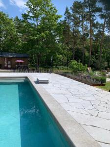 - une piscine dans une cour avec une terrasse en pierre dans l'établissement Exklusivt kalkstenshus från 1850 med arkitektritad pool, à Klintehamn