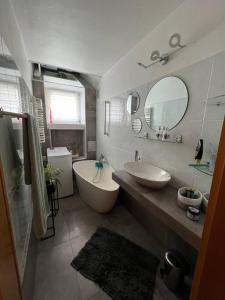 een badkamer met een bad, een wastafel en een spiegel bij Pokój w mieszkaniu współdzielonym Opole Centrum in Opole