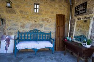 a bedroom with a blue bed in a stone wall at Eira Grande Galicia Villas in Pedre