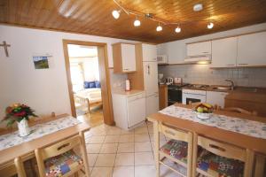 a kitchen with white cabinets and a table with chairs at Ferienhaus Maxi in Sankt Blasen