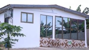 Casa blanca pequeña con ventanas grandes en Holly House, en Accra