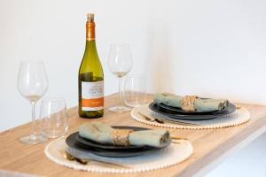un tavolo con una bottiglia di vino e bicchieri di L'écrin des Bois - Proche aéroport Beauvais, Chantilly, forêt de Hez-Froidmont, parking public gratuit, Wifi & Netflix a Clermont