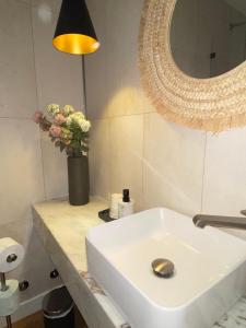 La salle de bains est pourvue d'un lavabo blanc et d'un miroir. dans l'établissement Grândola Suites - Suite Afonso, à Grândola