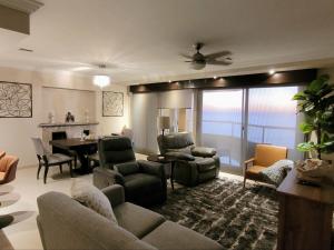 sala de estar con sofá, sillas y mesa en 2BD Beach Front Condo with Pool & More, en Rosarito