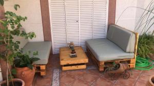 2 sillas y una mesa de centro en el patio en Familia Anfitriona acoge terraza, en Sevilla