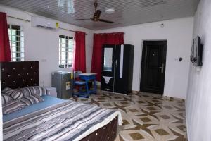 1 dormitorio con 1 cama y cortinas rojas en Holly House, en Accra