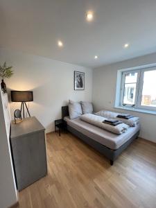 Llit o llits en una habitació de Gemütliches Studio-Apartment in Karlsruhe Neureut - Nähe Uni-KIT-Messe, Fußbodenheizung, Regendusche, Waschmaschine, Stellplatz