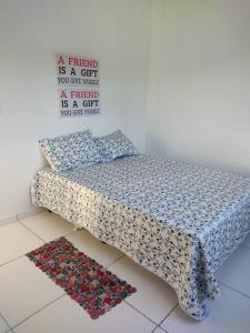 a bed in a room with a pillow and a rug at Casa de Praia em Condomínio Fechado em Alagoas! in Paripueira