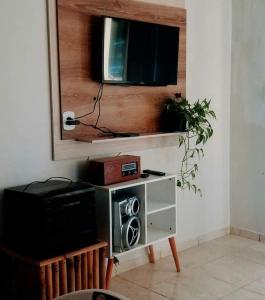 a living room with a tv on a wall at Casa B com Piscina Enseada Ubatuba Max06 Hosp in São Francisco do Sul