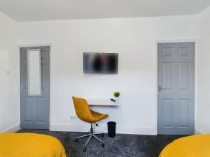 um quarto com 2 camas, uma secretária e uma televisão em Cliff House By RMR Accommodations - NEW - Sleeps 8 - Modern - Parking em Stoke on Trent