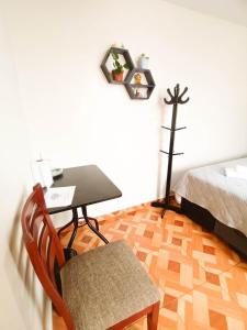een slaapkamer met een bureau en een bed en een tafel en stoel bij A y J Familia Hospedaje in Lima