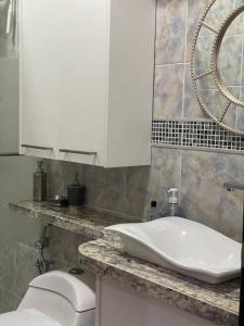 a bathroom with a sink and a toilet at Moderna Suite en Machala in Machala