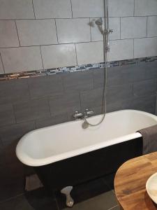 uma banheira com chuveiro na casa de banho em Appartement au cœur du Village em Saorge