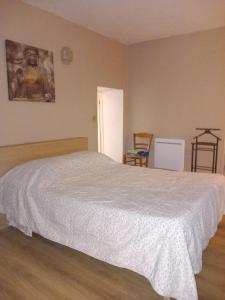 um quarto com uma cama com uma colcha branca em Appartement au cœur du Village em Saorge