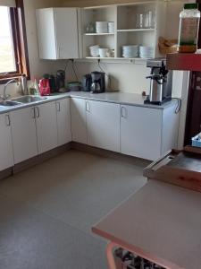 cocina con armarios blancos y lavabo en una habitación en Áfangi en Blönduós