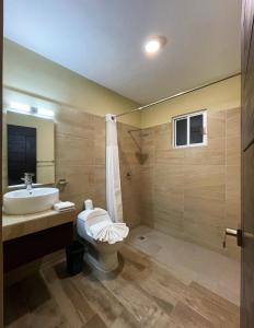 uma casa de banho com um WC, um lavatório e um chuveiro em Ammare Hotel Boutique em Playa del Carmen