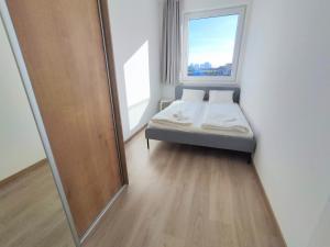 a small bedroom with a bed and a mirror at Quietly oriented apartment with free parking and balcony in Bratislava