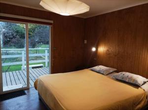 een slaapkamer met een bed en een glazen schuifdeur bij Casa en el Campo Paine in Maipo