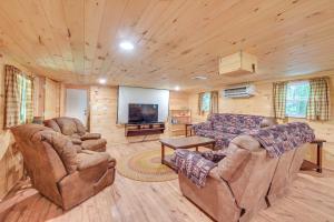 a living room with couches and a flat screen tv at Serene Centre Hall Cabin with Stream On-Site! in Centre Hall