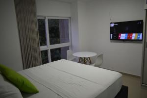 sypialnia z białym łóżkiem i oknem w obiekcie Apartaestudio en el peñón 304 w mieście Cali