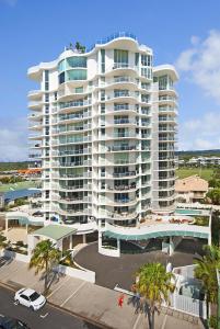 a large white apartment building with a parking lot at Aqua Vista Resort in Maroochydore