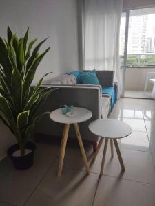 uma sala de estar com duas mesas e um sofá em Apartamento de 2 quartos no Recife