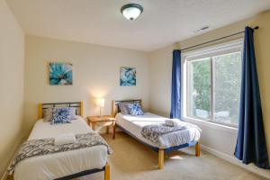 two beds in a room with a window at Bend Getaway with Private Hot Tub, Patio and Grill! in Bend