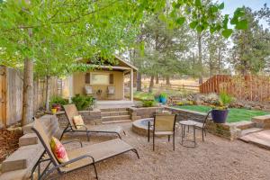 a backyard with chairs and a table and a fire pit at Bend Getaway with Private Hot Tub, Patio and Grill! in Bend