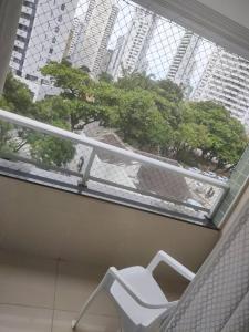 Una silla blanca sentada en un balcón de un edificio. en Apartamento de 2 quartos, en Recife