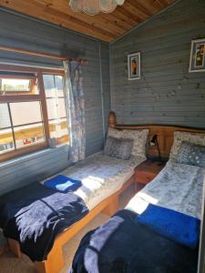 BallantraeにあるUnique Caravan with Outdoor Space Lodgeのログキャビン内のベッドルーム1室(ベッド2台付)