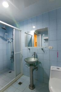 a bathroom with a sink and a shower and a toilet at HC Inn in Hengchun