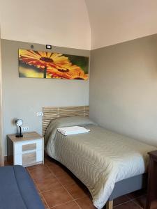 1 dormitorio con 1 cama y una pintura en la pared en Da Sciuri case vacanza Barisciano, en Barisciano