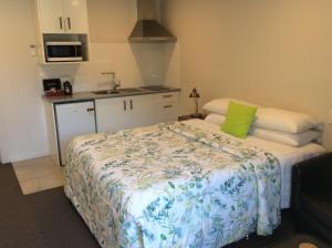 a bedroom with a bed with a green pillow on it at Acacia Lake View Motel in Taupo