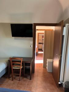 Dormitorio con escritorio, cama y TV en Da Sciuri case vacanza Barisciano, en Barisciano